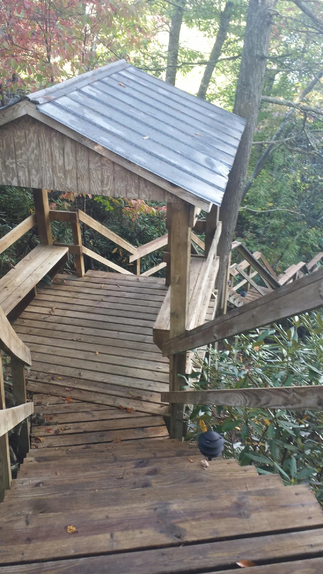 Metal roofed shelter over wooden steps on a wooded walkway — Skylight Repair & Installation work by our crew in Hookstown