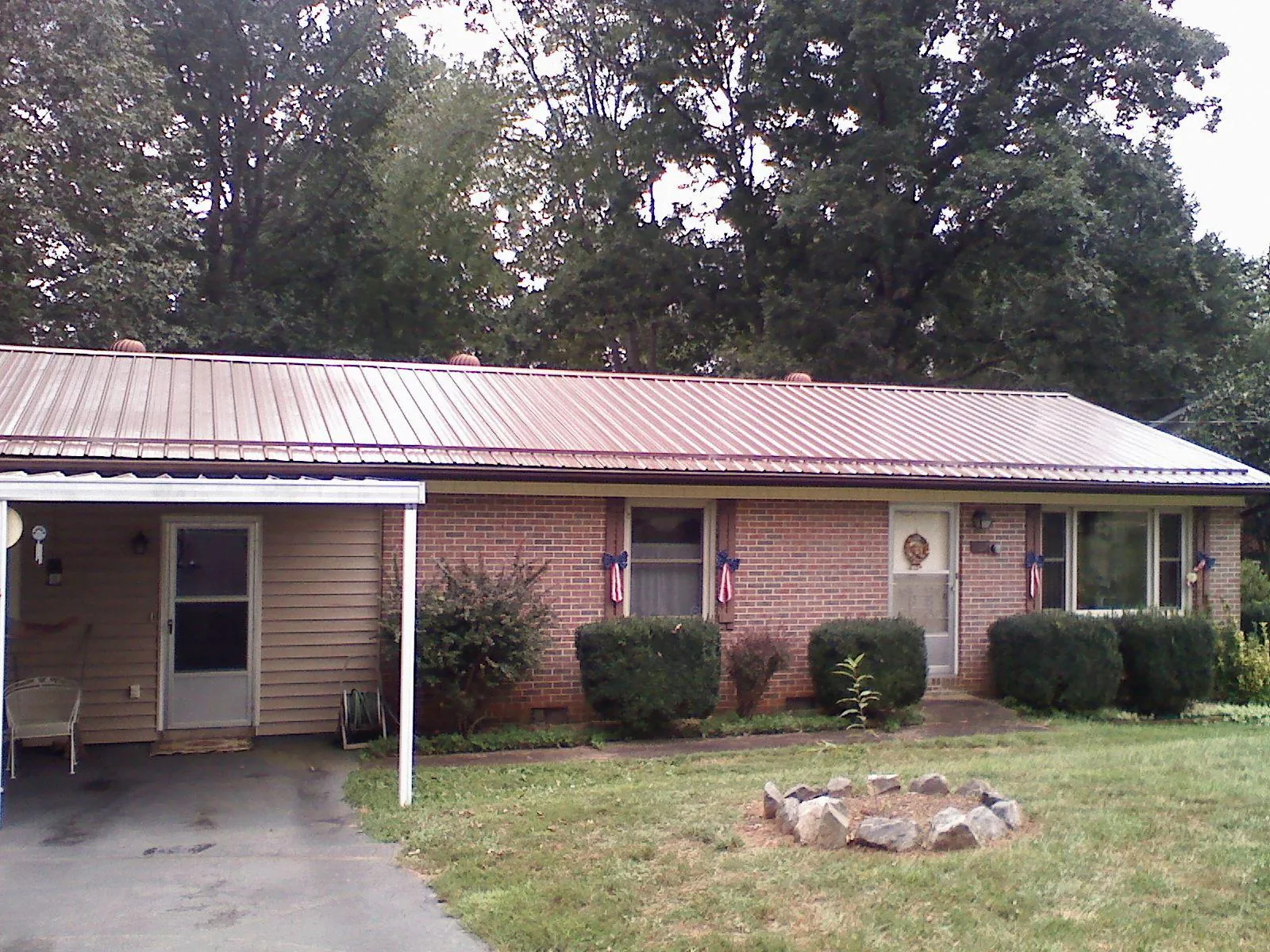 Bronze metal roof and carport on a brick ranch home — Roof Repair work by our crew in Hookstown