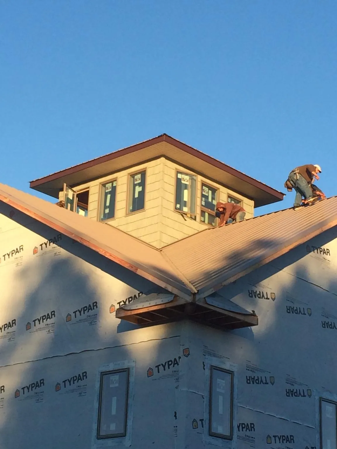 Roofers working around a rooftop cupola on a new metal roof at sunset — Roof Waterproofing in Hookstown by Roofing Brothers